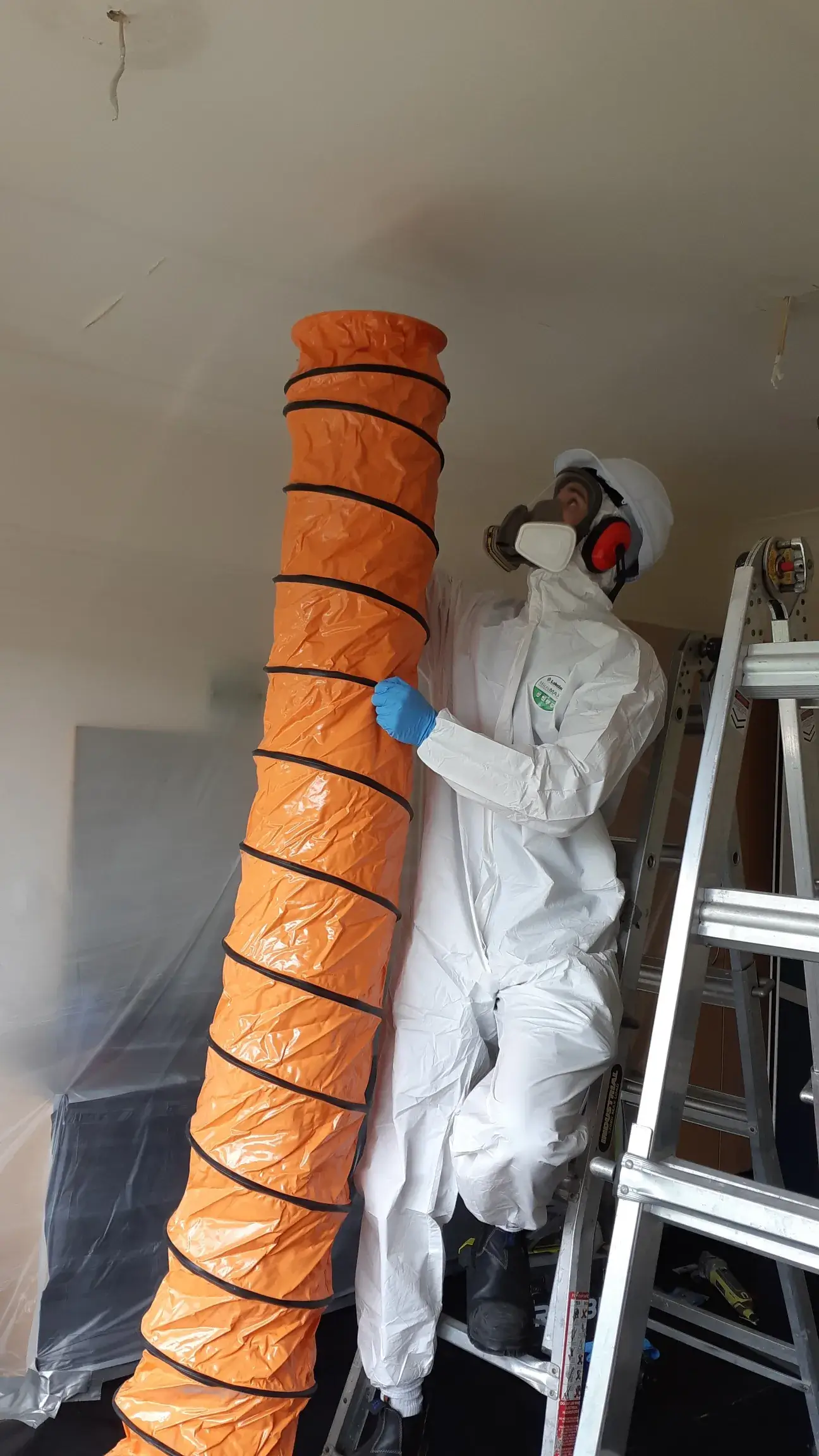 CSS technician during asbestos removal in full PPE